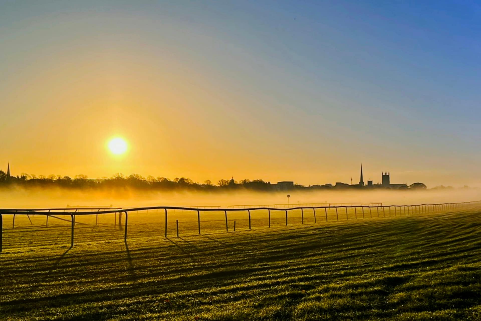 Sunrise and morning mist over the running rail at Worcester Racecourse, a race day ahead for the Tote Jackpot