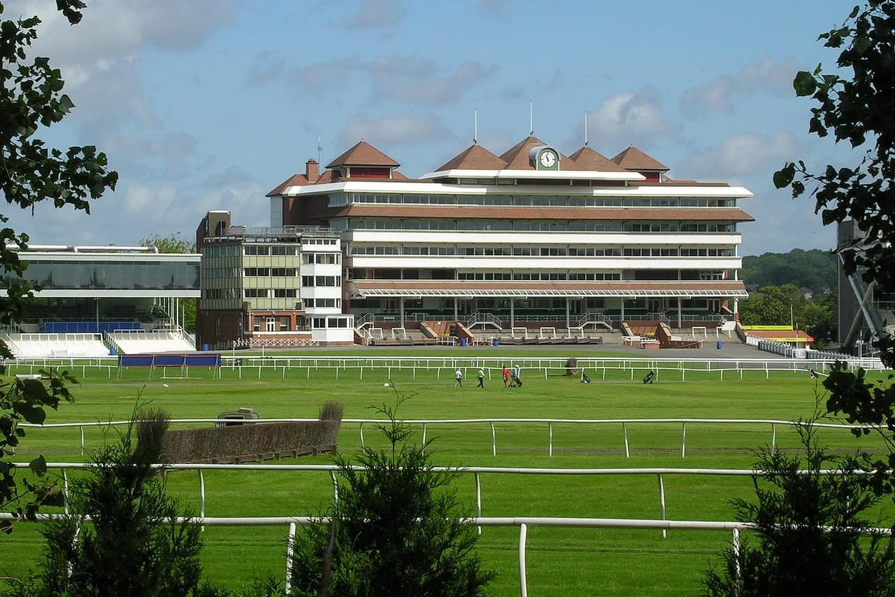 The grandstand at Newbury Racecourse seen across the empty track on a sunny day